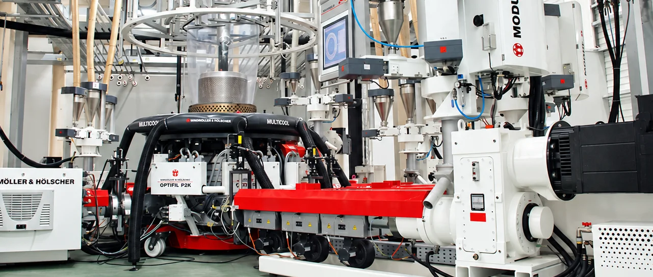 Windmöller & Hölscher multi-layer co-extrusion blown-film line with its red extruder, air ring and film bubble