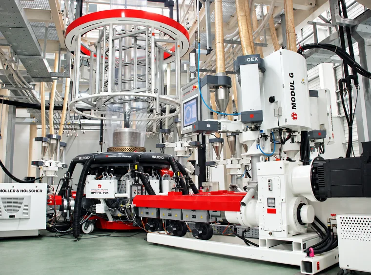 Windmöller & Hölscher multi-layer co-extrusion blown-film line: extruders, air ring and the film bubble rising to the cooling tower