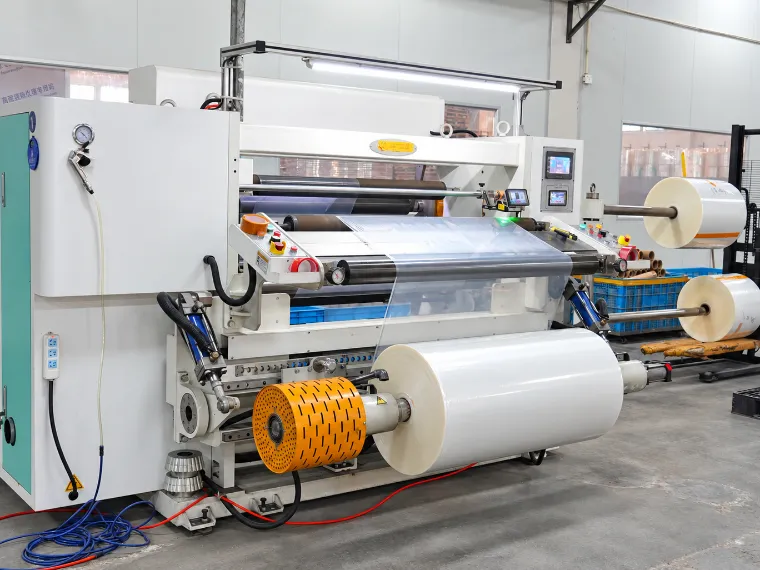 Slitter rewinder cutting a wide film web into finished rolls